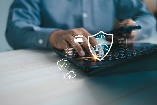 Professional working on laptop with digital safety shield and icon interface. Concept of workplace safety management, compliance monitoring, risk prevention, and occupational health protection.