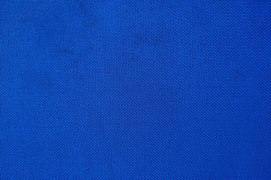 Blue textured fabric background close up with vibrant canvas weave pattern