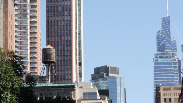 New York City Midtown urban building architecture, Manhattan rooftop, United States of America. Water tower on roof. Classic water tank and modern skyscraper tower from glass.