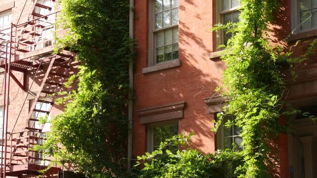 New York City urban residential buildings architecture, Manhattan classic street, United States of America. Typical red brick house in NYC, real estate property in USA. Fire escape metallic ladder.