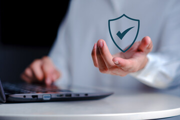 Business digital shield with check mark above laptop, symbolizing cybersecurity protection, secure data management, privacy compliance, risk control, and trusted digital security systems
