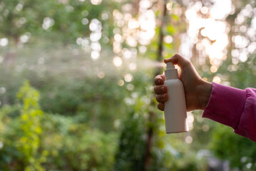 Unrecognizable woman using insect sprays disease prevention. Protection against mosquito bite during summertime. Safety skin treatment outdoors © anna.stasiia