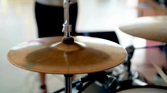 Close-up of a cymbal on a drum set shrouded in smoke Slow motion American man playing drums in music rehearsal studio Male hitting drum metal cymbals