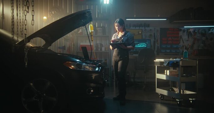 Woman Technician Performs Digital Vehicle Diagnostics, Laptop Open On Engine Bay While Tablet Assists With AI Based Troubleshooting. Female Reviews Parameters, Searches For Optimal Repair Solutions.
