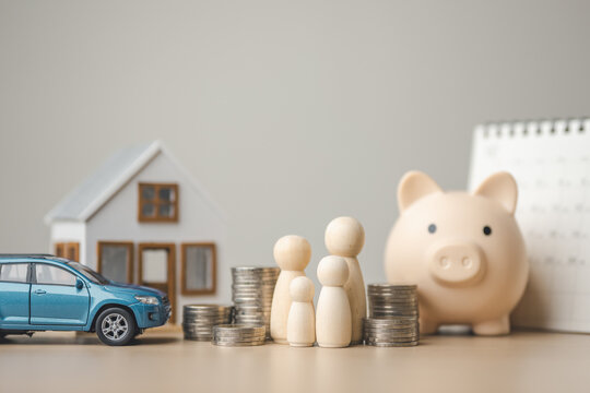 Family financial planning concept with house model, car, piggy bank and stacked coins. Represents personal asset management, savings deposit, insurance protection, retirement planning.