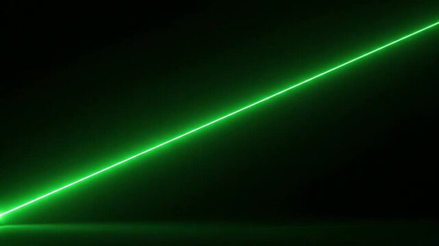 A green laser beam in motion cuts through darkness, illuminating a dark room with a sense of technology and science.