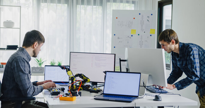 Team of male developers work code control robotics system and software automation project write prompt AI data bot at office. Artificial intelligence, collaboration, robotic, debugging, machine learn.