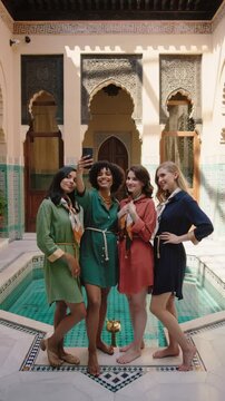 Moroccan Riad Selfie: Four Friends Taking a Photo in a Traditional Courtyard with a Pool 