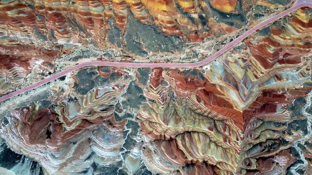 Aerial drone view of vividly layered sedimentary rock formations at Zhangye Danxia Landform Geological Park in Gansu Province, China
