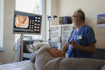 Fototapeta premium Doctor looking at monitior during gastroscopy procedure, examining upper digestive tract.