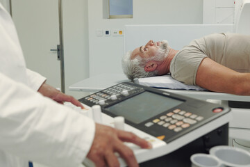 Doctor operationg CT machine in hospital.