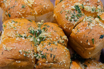 Delicious golden brown garlic bread rolls with fresh chopped herbs baked perfectly for dinner