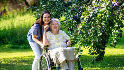Home nurse taking care of elderly woman in wheelchair.