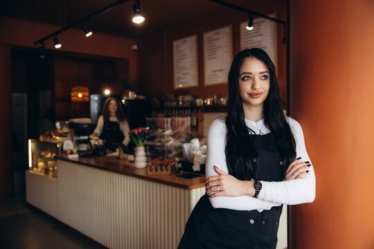 Woman barista smiling preparing drinks in coffee shop