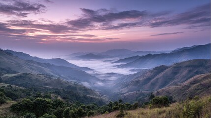 Fototapeta premium Breathtaking Sunrise Over Serene Mountain Landscape with Mist and Fog in Lush Greenery and Vibrant Sky Colors