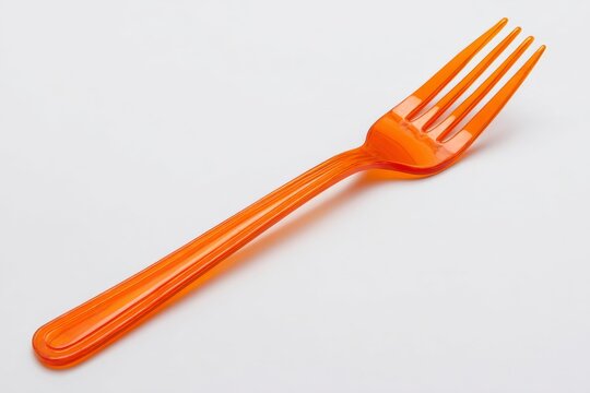 Orange plastic fork on white background 1.