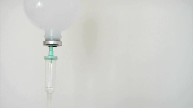 drip chamber dripping into patient A mixture of sodium chloride or salt and water Close up on Set IV fluid intravenous drop saline on a dark blue