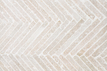 Textured surface featuring herringbone pattern in light colors for modern design projects
