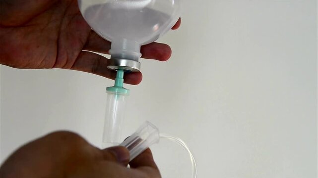 drip chamber dripping into patient A mixture of sodium chloride or salt and water Close up on Set IV fluid intravenous drop saline on a dark blue