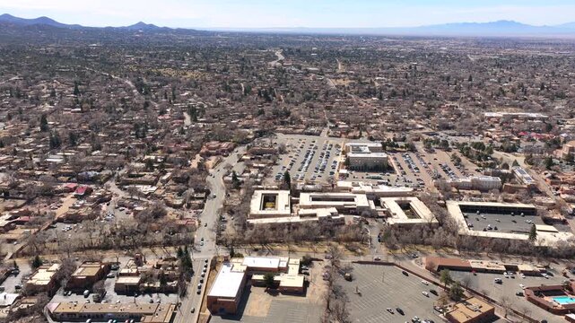 sweeping wide shot captures the expansive Santa Fe skyline against a stunning mountain backdrop. This 4K vista highlights the blend of historic adobe design and natural scenery.