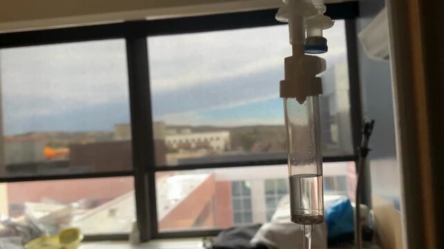 drip chamber dripping into patient A mixture of sodium chloride or salt and water Close up on Set IV fluid intravenous drop saline on a dark blue