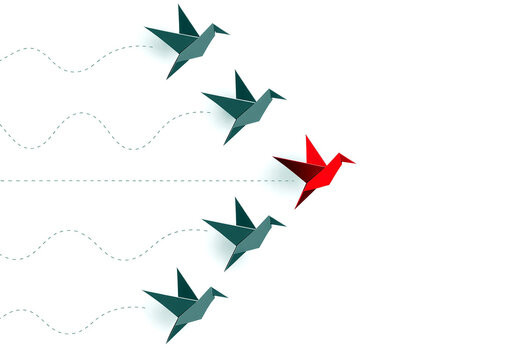 Colorful origami birds flying in formation with one leading red bird breaking away creatively