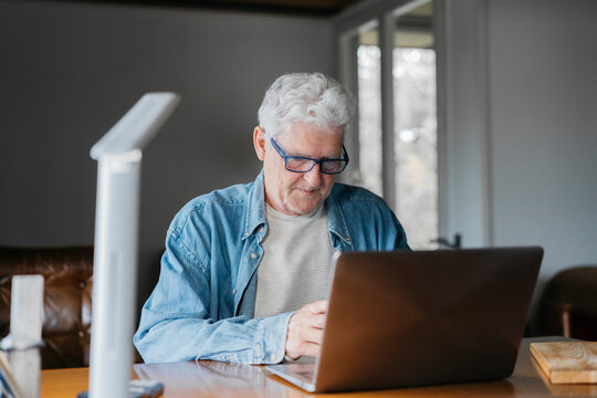 Senior man using laptop at home