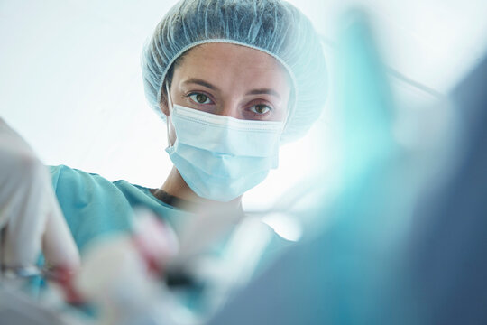 Confident female surgeon operating in intensive care unit at hospital