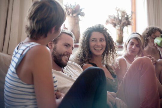 Happy male and female friends spending leisure time together at home