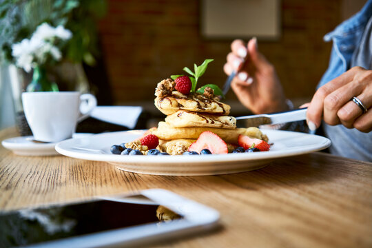 Close-up of woman eating pancakes in cafe