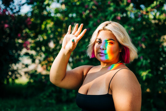 Woman stopping light reflection with hand at park