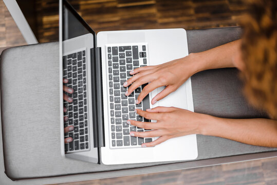 Young woman typing on laptop, view from abaove
