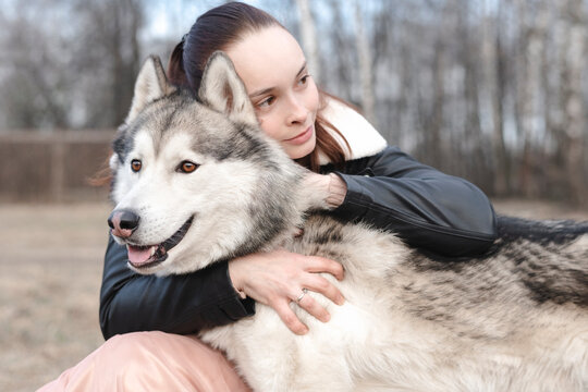Portrait of happy woman cuddling her husky