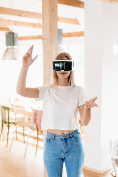 Young woman wearing VR goggles, designing her new home