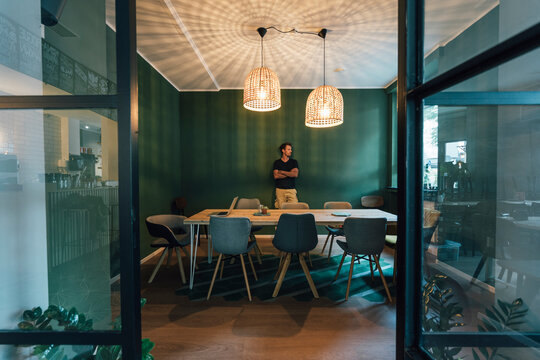 Man standing alone in office of his start up company, working long hours