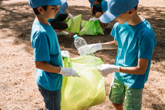 Group of volunteering children collecting garbage in a park