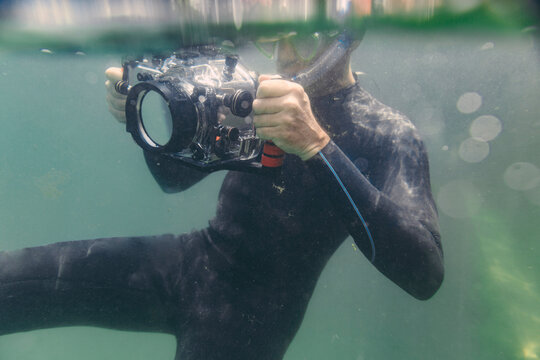Man diving with underwater DSLR camera case