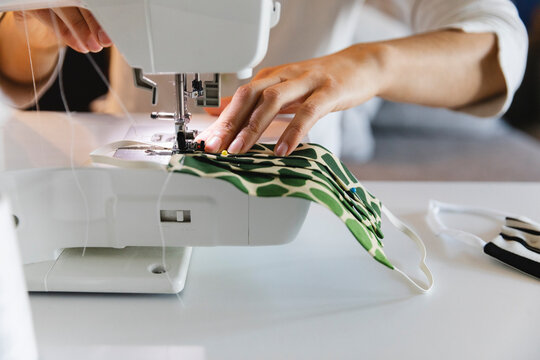Woman sewing protective face mask at home