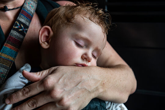 Mother embracing sleeping baby son
