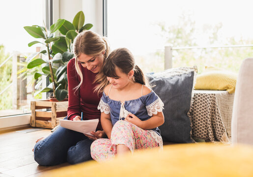 Mother helping daughter with homework at home