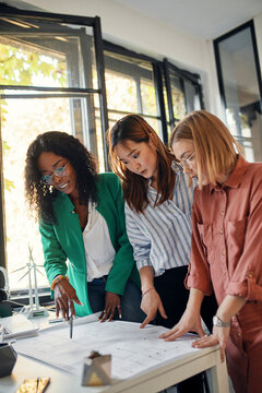Businesswomen having a meeting in office with wind turbine models on table