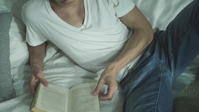 Man enjoying reading a book in sunny bedroom