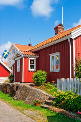 Idyllic Swedish red wooden cottage by a street sunny summer day © Lars Johansson