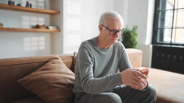 Elderly man surfing internet by modern smartphone, using mobile app for shopping . Modern technology and aged people, senior male user testing new application for communication, phone addiction