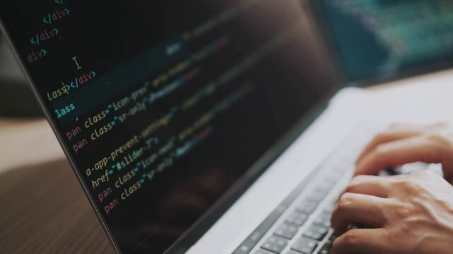 Close up of male hands typing programming on screen laptop Camera slides around developer's figers writing program code on computer display background