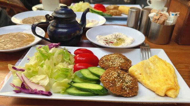Traditional Egyptian Breakfast Spread with Falafel Taameya Omelet Vegetables and Tea
