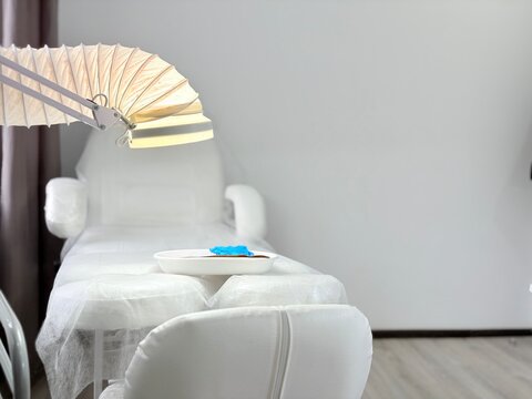 White pedicure chair with foot care tools tray and dust extractor in a clean salon environment