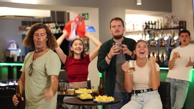 Happy sports supporters with flag of Croatia, rejoicing winning game with beer and snacks in pub. High quality 4k footage