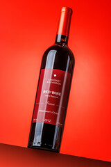 Naklejka premium Red wine bottle mockup on red background