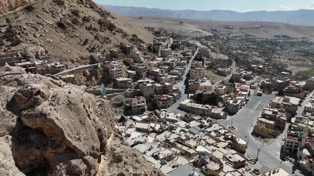 Cinematic aerial vista of Ma'loula, Syria dramatic location within the Qalamoun Mountains